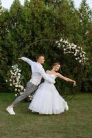 le premier Danse de le jeune marié et la mariée dans une court mariage robe sur une vert Prairie photo