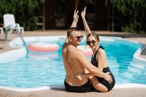 gars et une fille dans baignade costume sont relaxant, près le bleu bassin photo