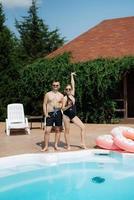 gars et une fille dans baignade costume sont relaxant, près le bleu bassin photo