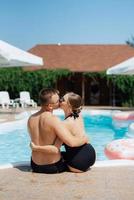 gars et une fille dans baignade costume sont relaxant, près le bleu bassin photo