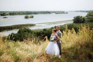 Jeune couple une gars et une fille sont en marchant dans le vert collines photo