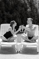 gars et une fille dans baignade costume sont relaxant, près le bleu bassin photo