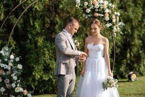 mariage la cérémonie de le jeunes mariés sur le clairière photo