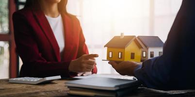 agent de courtage immobilier présentant et consultant le client pour la prise de décision signant un accord de formulaire d'assurance, modèle d'achat et de vente de maison, concernant l'offre de prêt hypothécaire et l'assurance habitation photo