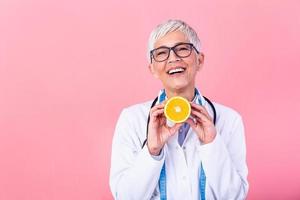 diététicien en portant un orange. souriant nutritionniste en portant une tranché orange, vitamines et en bonne santé régime concept. bien médical soins de santé nutrition concept. photo