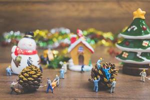 Personnes miniatures créant des décorations de Noël sur un fond de bois