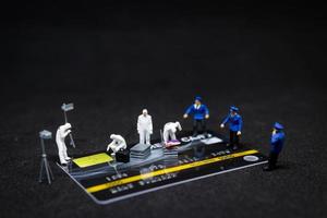 police miniature et détectives sur une scène de crime sur les cartes de crédit, concept de cybercriminalité photo