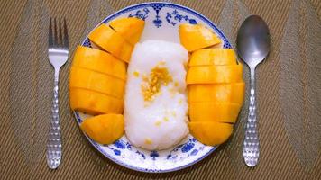 mangue gluant riz surmonté avec noix de coco Lait et soja mis dans une traditionnel chinois style plat sur une en bois tableau. photo