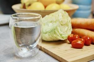 verre d'eau propre et légumes photo