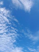 beaux nuages blancs sur fond de ciel bleu profond. de grands nuages doux et moelleux couvrent tout le ciel bleu. photo