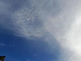 beaux nuages blancs sur fond de ciel bleu profond. de grands nuages doux et moelleux couvrent tout le ciel bleu. photo