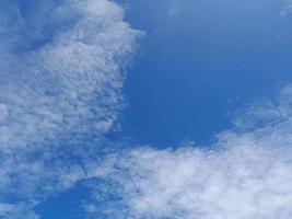 beaux nuages blancs sur fond de ciel bleu profond. de grands nuages doux et moelleux couvrent tout le ciel bleu. photo