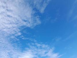 beaux nuages blancs sur fond de ciel bleu profond. de grands nuages doux et moelleux couvrent tout le ciel bleu. photo