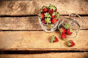 fraises dans un verre sur une table en bois photo