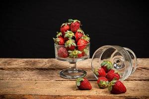 fraises dans un verre sur une table en bois photo