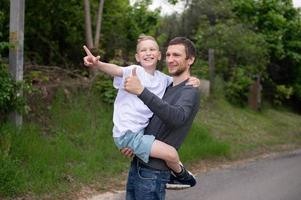 le garçon est séance dans papa bras et elles ou ils sont en riant photo