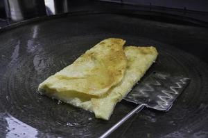 friture Martabak telor ou omelette Martabak dans chaud huile. sarriette poêlé Pâtisserie farci avec œuf, Viande, et épices. traditionnel nourriture collations de Indonésie. photo