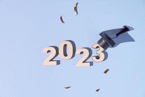 concept de classe de 2023. numéros 2023 avec capuchon noir gradué sur fond coloré photo
