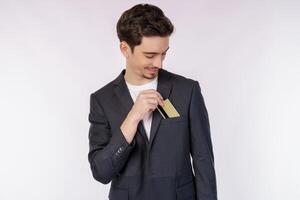 portrait d'un jeune homme d'affaires souriant et beau montrant une carte de crédit isolée sur fond blanc photo