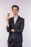 portrait d'un jeune homme d'affaires souriant et beau montrant une carte de crédit isolée sur fond blanc photo