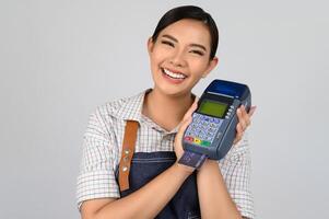 portrait de jeune femme asiatique en uniforme de serveuse pose avec carte de crédit photo