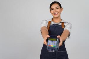 portrait de jeune femme asiatique en uniforme de serveuse pose avec carte de crédit photo