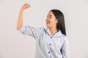 portrait de jeune femme asiatique montrant le geste du gagnant sur fond blanc isolé photo