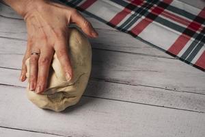 le du chef mains préparer et pétrir Frais fait maison Pizza pâte sur le cuisine table photo