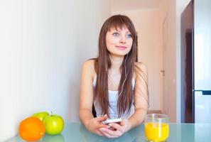 Jeune fille dans le cuisine écoute à la musique sur écouteurs photo