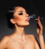 portrait de une magnifique femme avec cigare et avec une glamour rétro maquillage photo