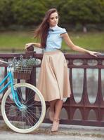 belle jeune femme élégamment vêtue avec vélo photo