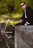 Jeune élégant gars avec vélo en plein air photo