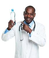 portrait de une souriant Masculin médecin en portant bouteille de l'eau sur blanc photo