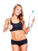 Jeune athlétique fille avec bouteille de l'eau sur blanc photo