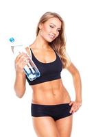 Jeune athlétique fille avec bouteille de l'eau sur blanc photo