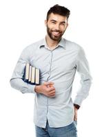 Jeune barbu souriant homme avec livres dans main sur blanc photo