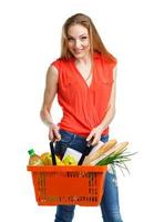 content femme en portant une panier plein de en bonne santé aliments. achats photo