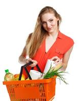 content femme en portant une panier plein de en bonne santé aliments. achats photo