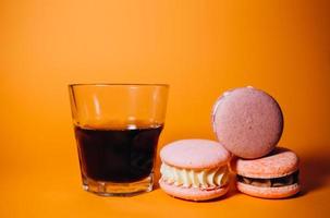 coloré macarons biscuits et noir café sur une blanc table photo