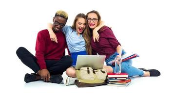 Trois content élèves séance avec livres, portable et Sacs photo