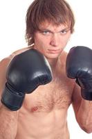 Jeune caucasien homme boxeur avec noir boxe gants. photo