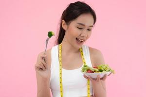 en bonne santé aliments. magnifique femelle fille souriant prendre plaisir manger Frais légume salade sur petit déjeuner santé. content asiatique femme bien émotion. suivre un régime, détox, régime, perdre lester, nettoyer manger, végétarien, nutritionniste photo