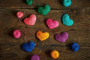 multicolore cœurs avec une des balles de fil sur vieux minable en bois Contexte photo