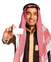 Jeune souriant arabe montrant affaires carte dans main isolé sur blanc photo