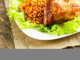 délicieux plat de poulet cuisse avec riz et salade feuilles photo