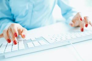 femme Bureau ouvrier dactylographie sur le clavier photo