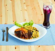 savoureux plat de rôti du boeuf avec riz et salade feuilles et une verre de jus avec la glace photo