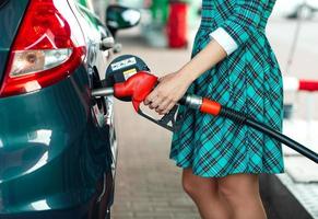 femme remplit essence dans le voiture à une gaz station photo