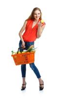 content femme en portant une panier plein de en bonne santé aliments. achats photo