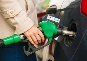 femme remplit essence dans sa voiture à une gaz station photo